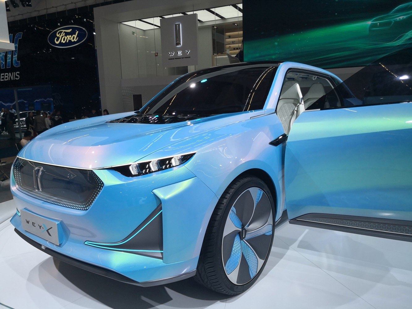Futuristic blue electric SUV with aerodynamic shape and LED headlights