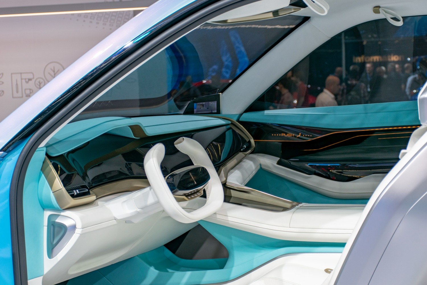 Futuristic turquoise and white car interior with unique steering wheel