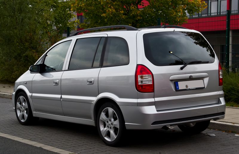 Silver mid-2000s multi-purpose vehicle rear and side view with roof rails and large windows