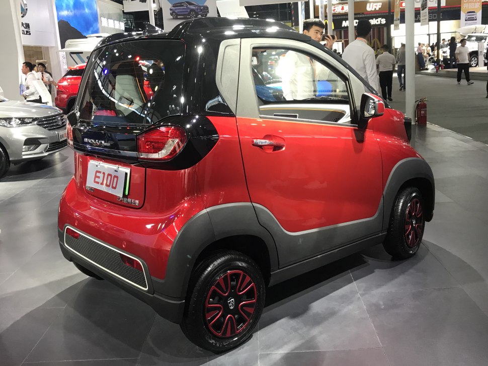 Compact two-tone electric microcar rear view with distinctive tire design