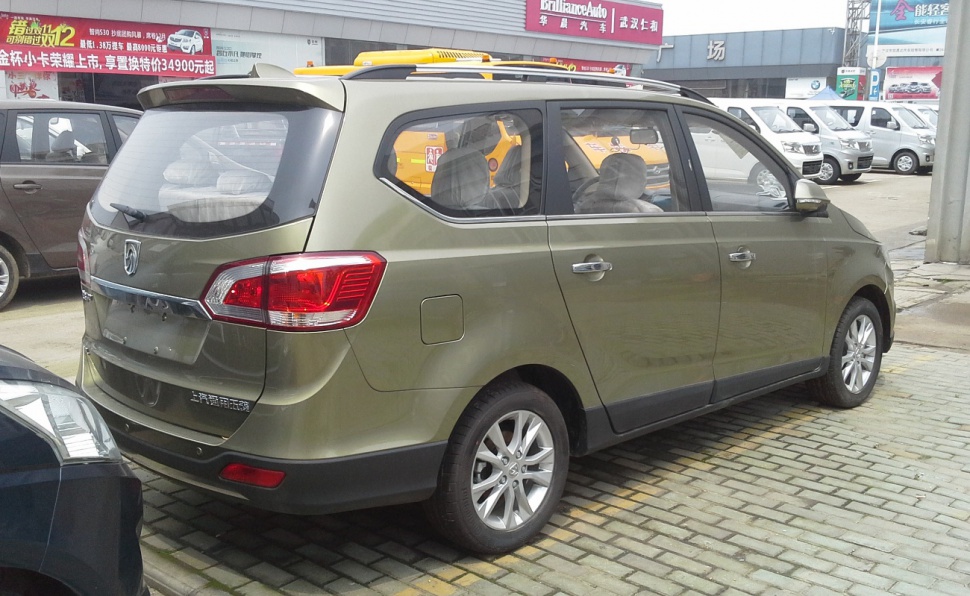Rear and side view of olive green multi-passenger MPV with distinct taillights and roof rails