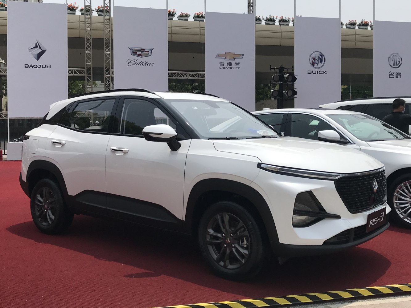 Front side view of white compact SUV with sharp headlights and black grille