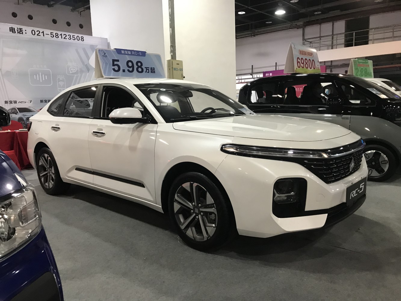 White modern sedan with LED daytime running lights and black front grille