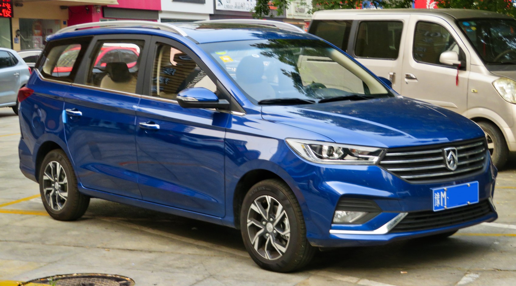 Blue multi-purpose vehicle with modern headlights and alloy wheels