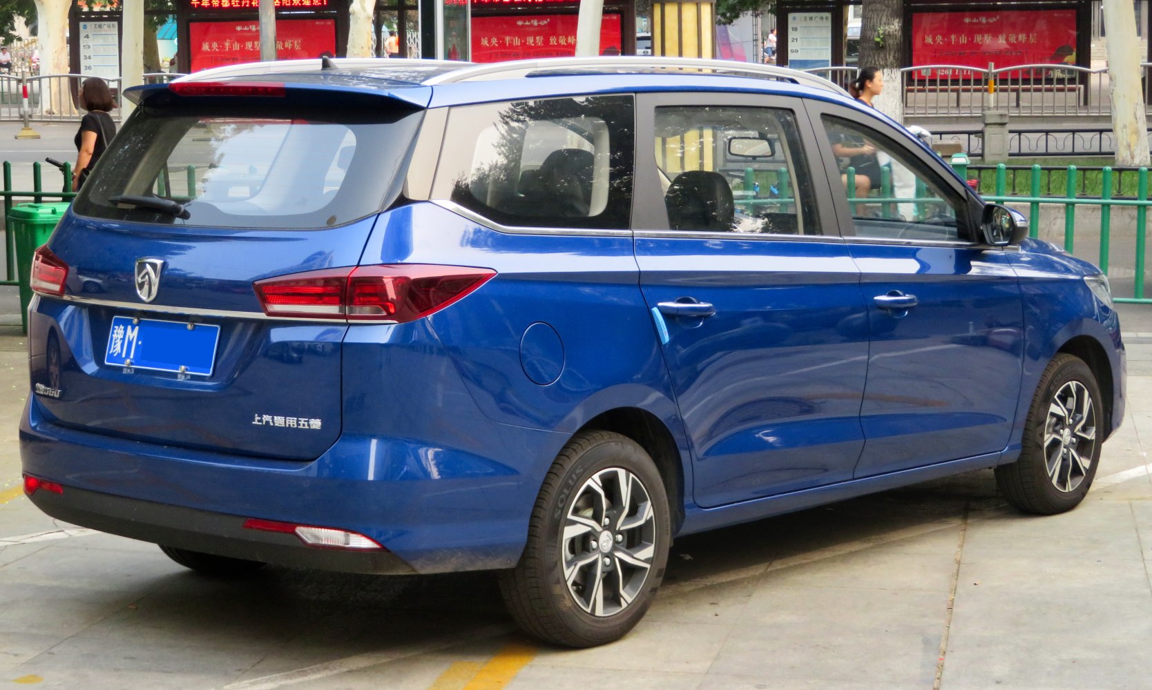 Rear and side view of a blue MPV with prominent taillights and alloy wheels