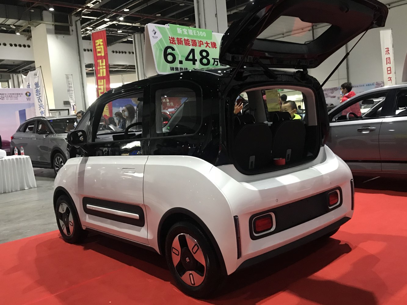 Rear hatch open, compact electric microcar with modern wheels