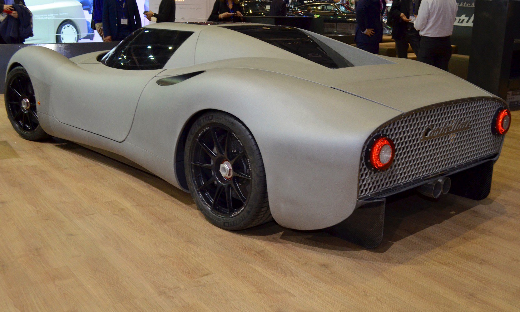 Rear side view of sleek aerodynamic concept car with round taillights and mesh grille