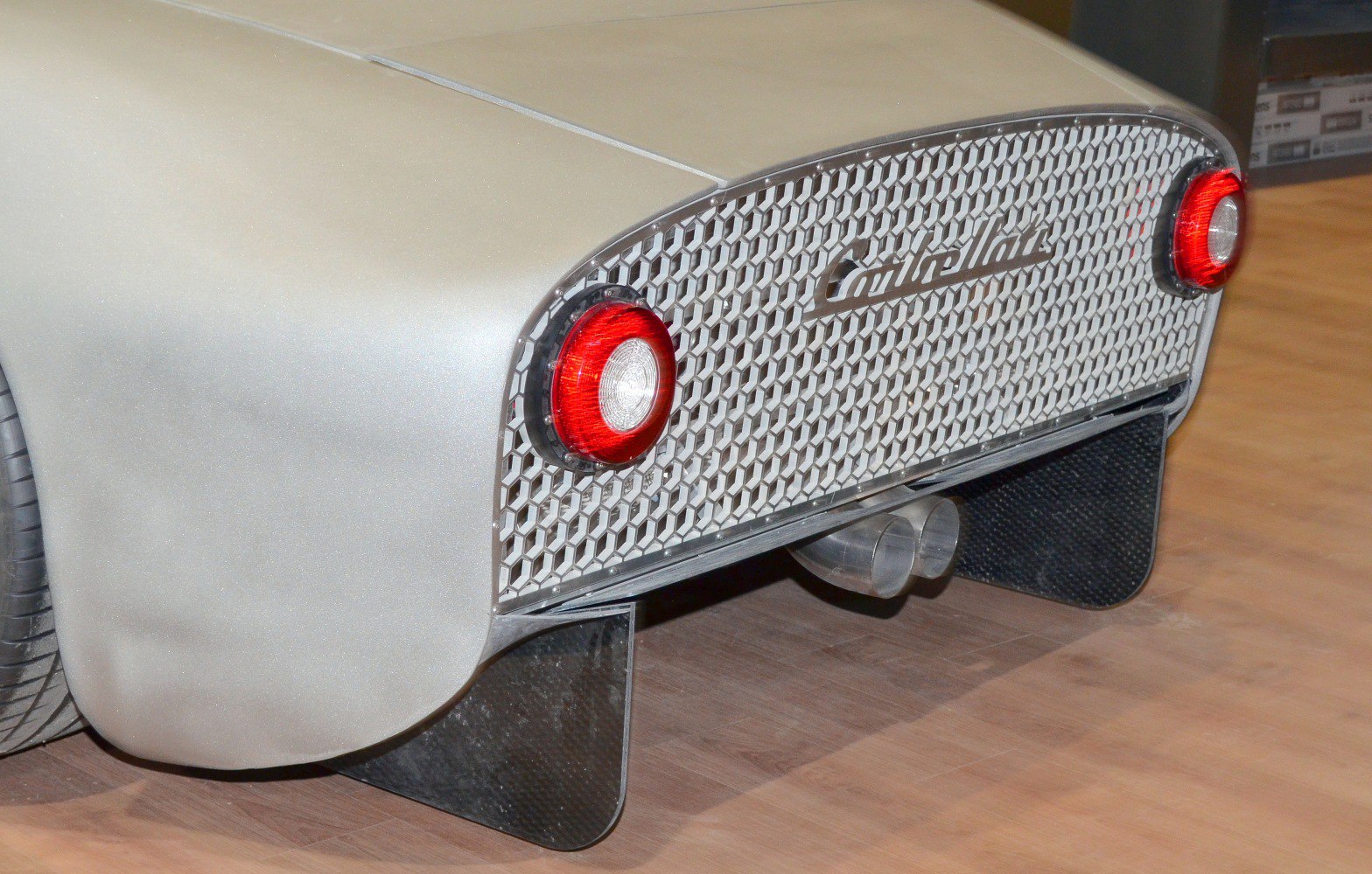 Rear design with hexagonal grille, round taillights, and dual exhaust pipes
