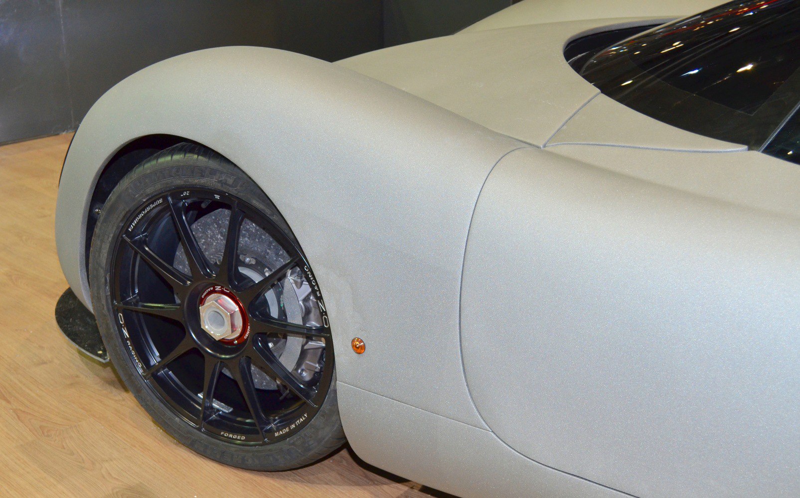Close-up of black alloy rear wheel and smooth car fender