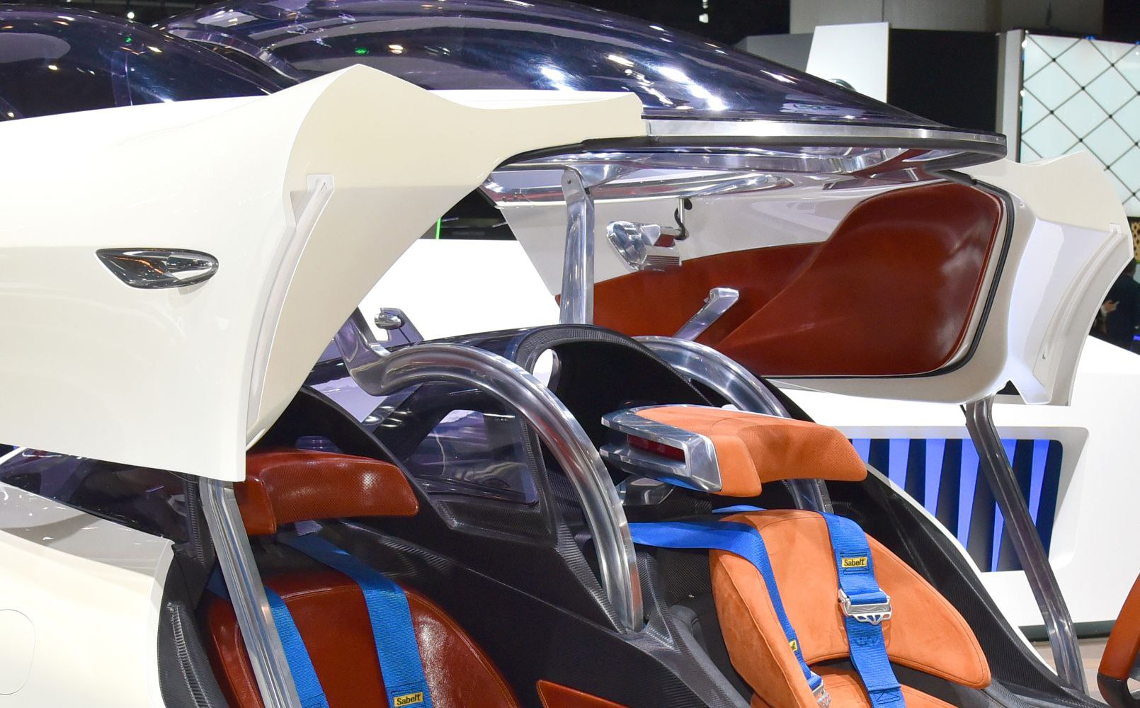 Car interior with colorful seats, blue harnesses, and a unique canopy door.
