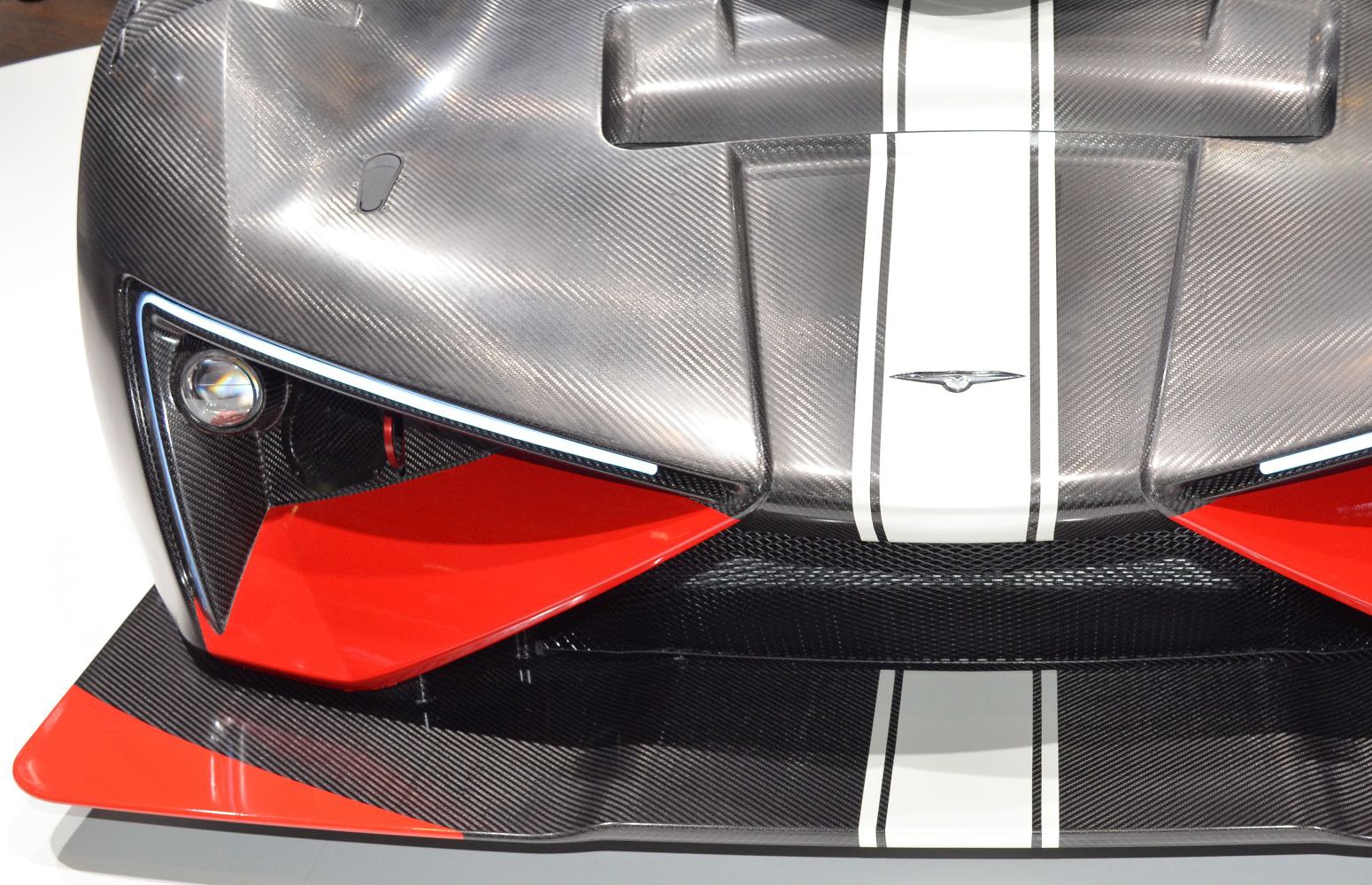 Carbon fiber front end with LED lights and red aerodynamic splitter accents