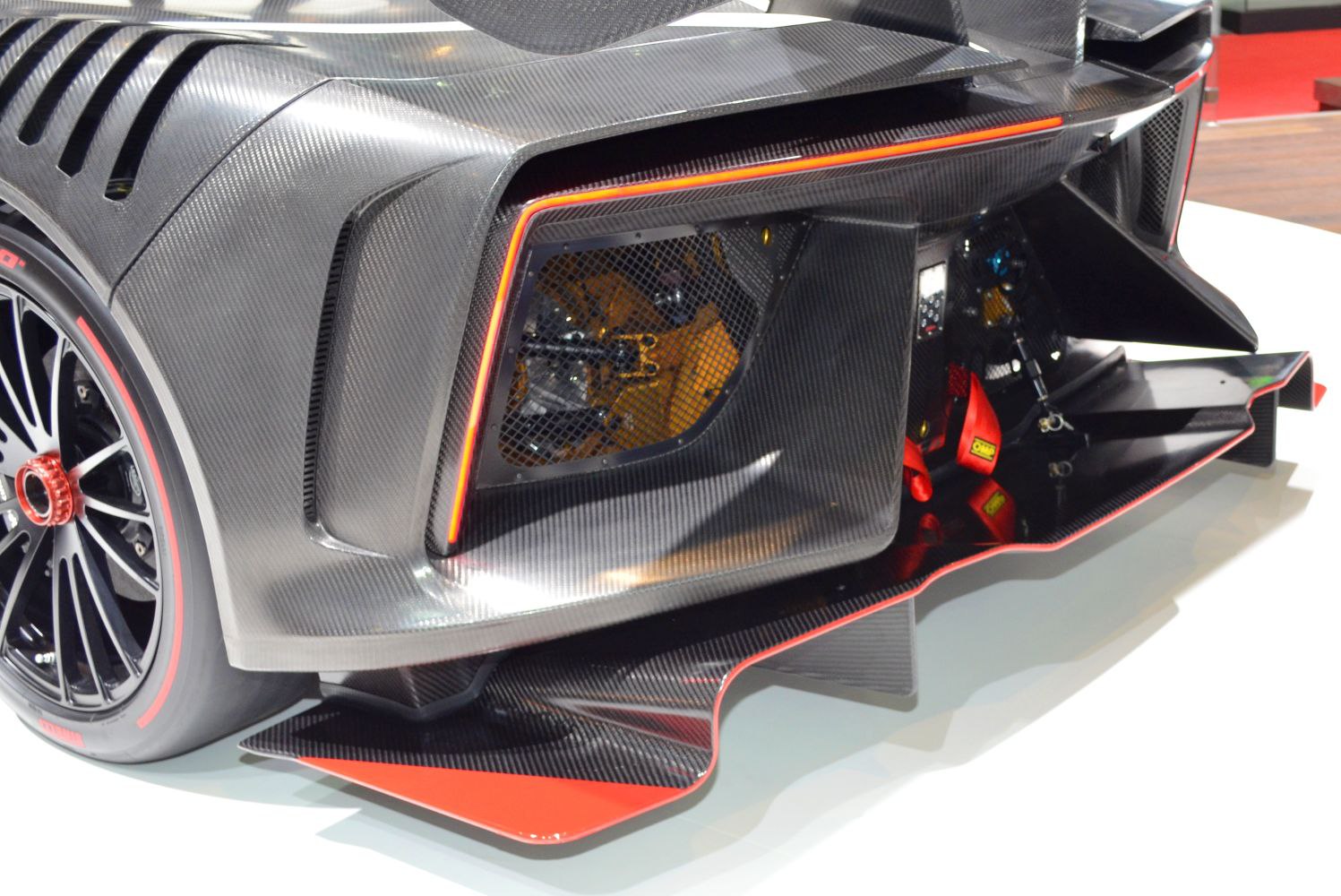 Carbon fiber rear diffuser, aerodynamic vents, and sporty wheel with red accents