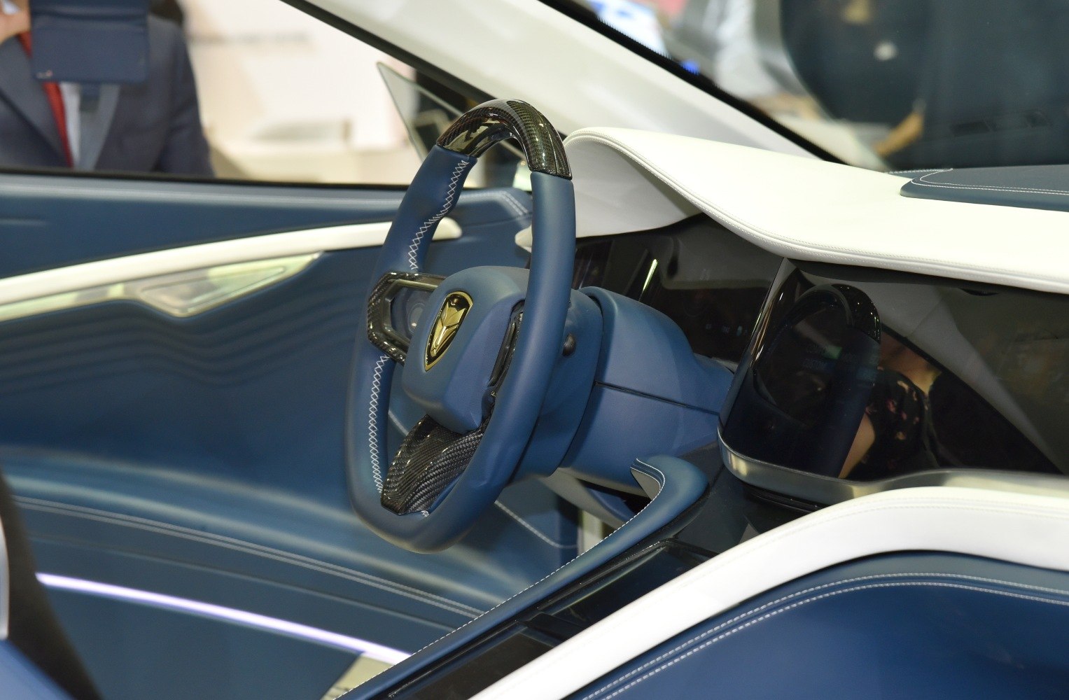 Blue steering wheel with carbon fiber accents and sleek dashboard design