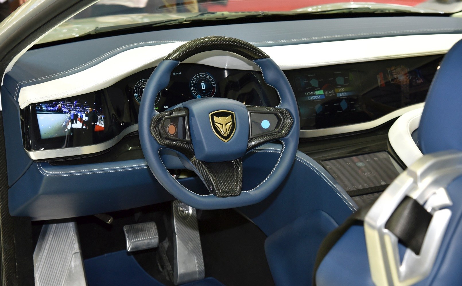 Digital instrument cluster and carbon fiber steering wheel with blue leather.