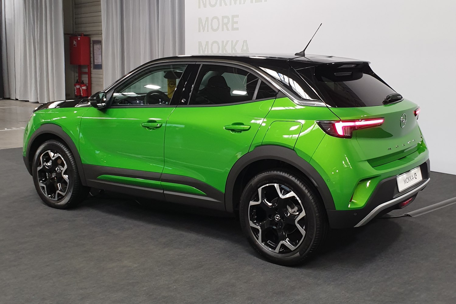 Rear side view of compact SUV with black roof and green exterior
