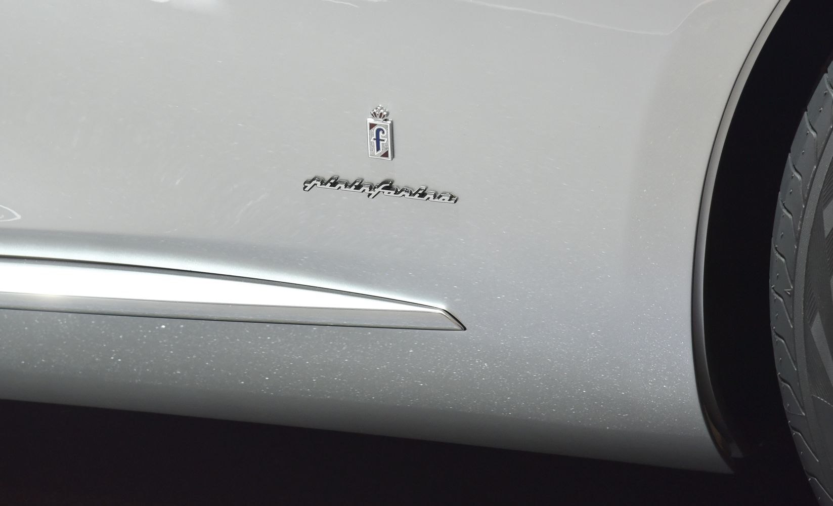 Close-up of Pininfarina badge and sleek side trim near wheel arch