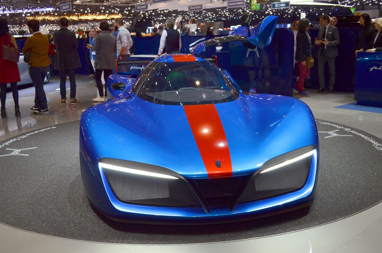 Blue hypercar with red racing stripe and gull-wing door