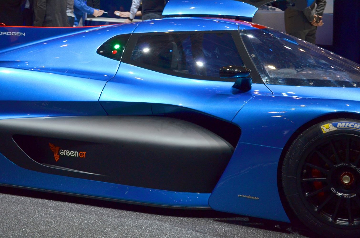 Blue aerodynamic side profile with Green GT branding and racing tire
