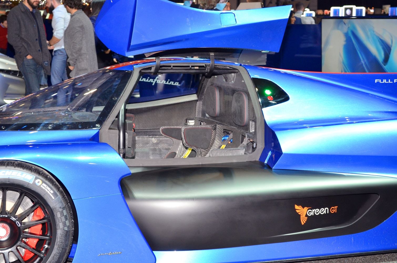 Blue hydrogen hypercar with open scissor door and carbon fiber racing cockpit