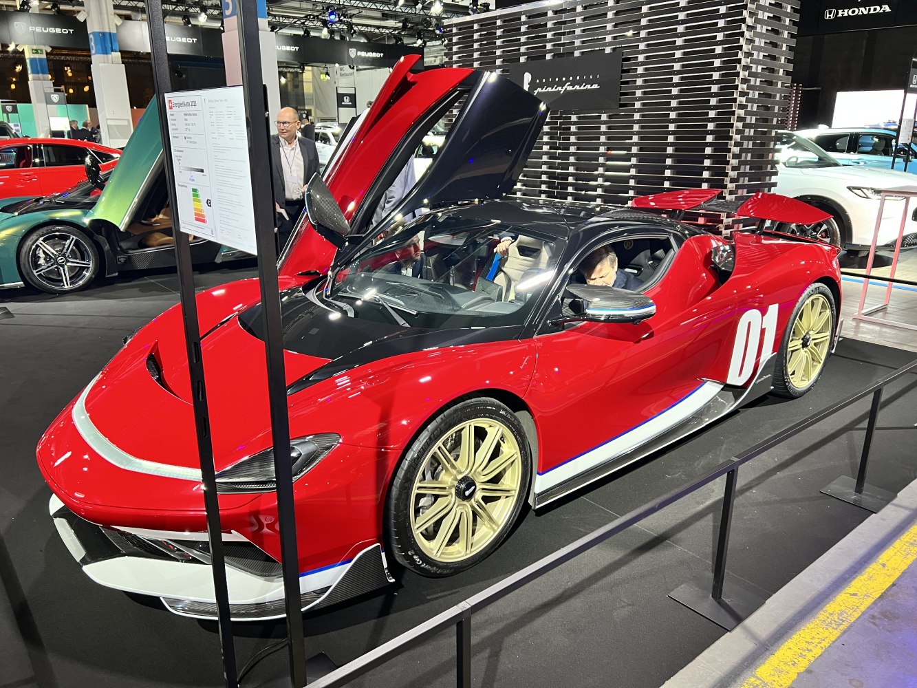 Red sports car with butterfly doors and gold wheels