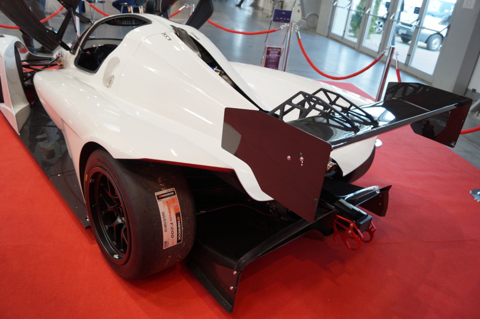 Rear aerodynamic wing with racing slick tire on lightweight sports prototype