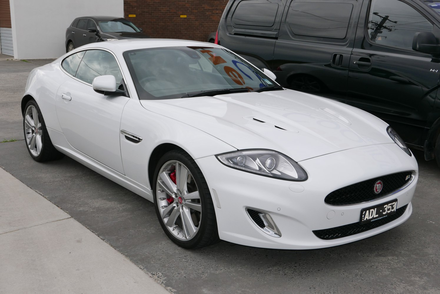 White luxury coupe with sleek headlights and alloy wheels front-side view