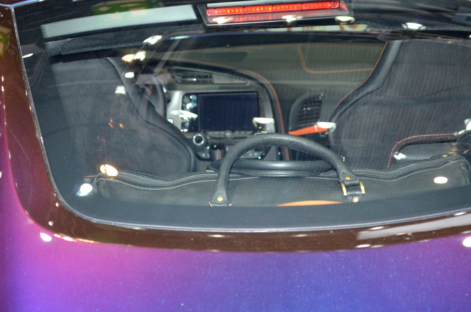 Car interior with seats and dashboard through rear window
