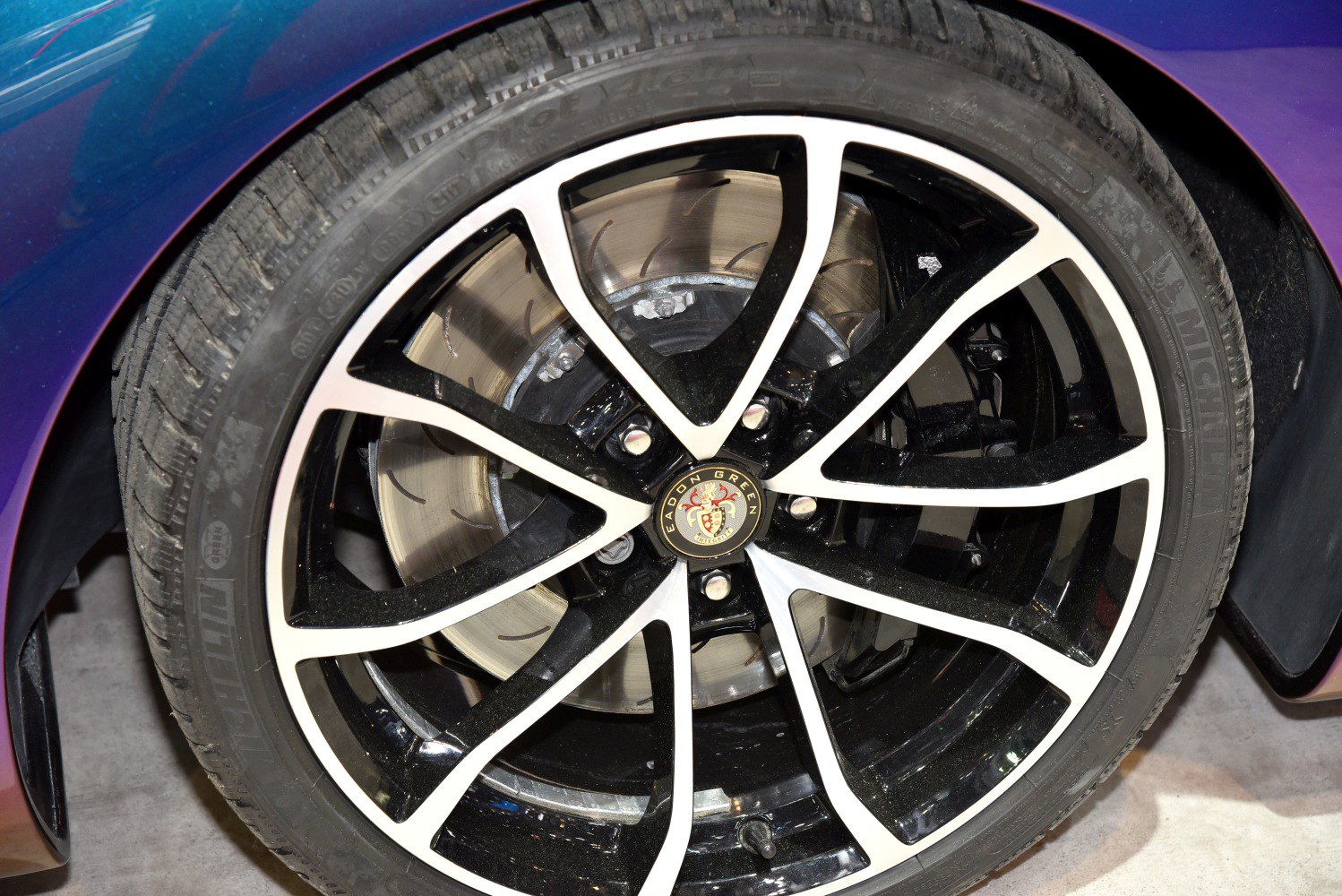 Black and silver alloy wheel with ventilated brake rotor and sports tire
