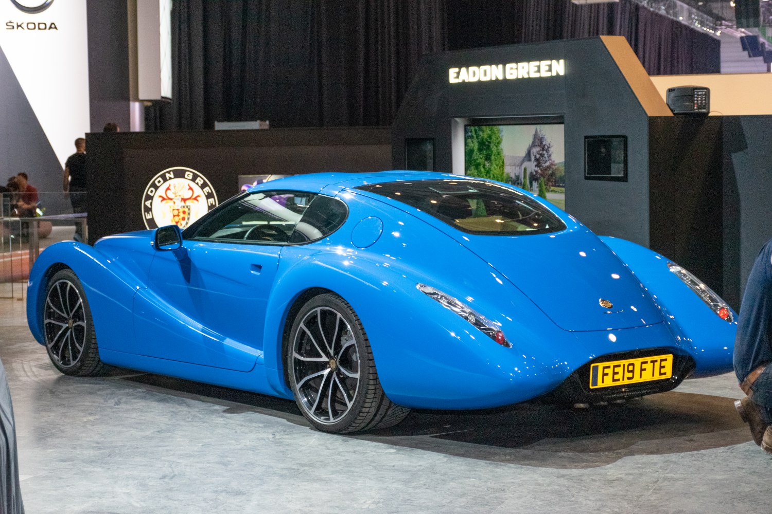 Streamlined blue sports coupe with aerodynamic shape and black multi-spoke wheels