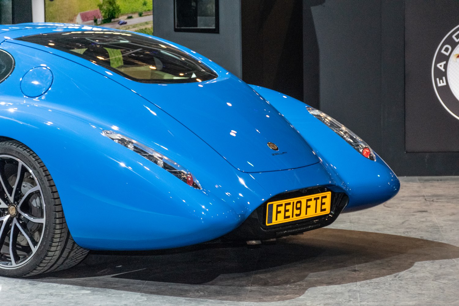 Sleek blue car rear with aerodynamic tail and distinctive tail lights