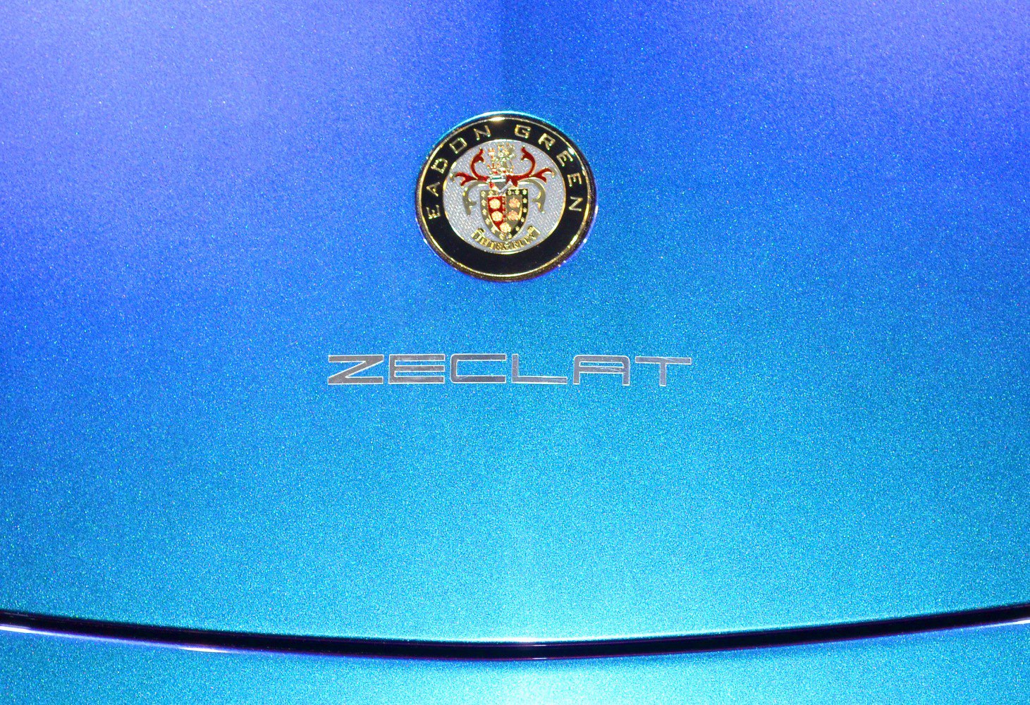 Close-up of Eadon Green Zeclat badge and emblem on blue metallic paint