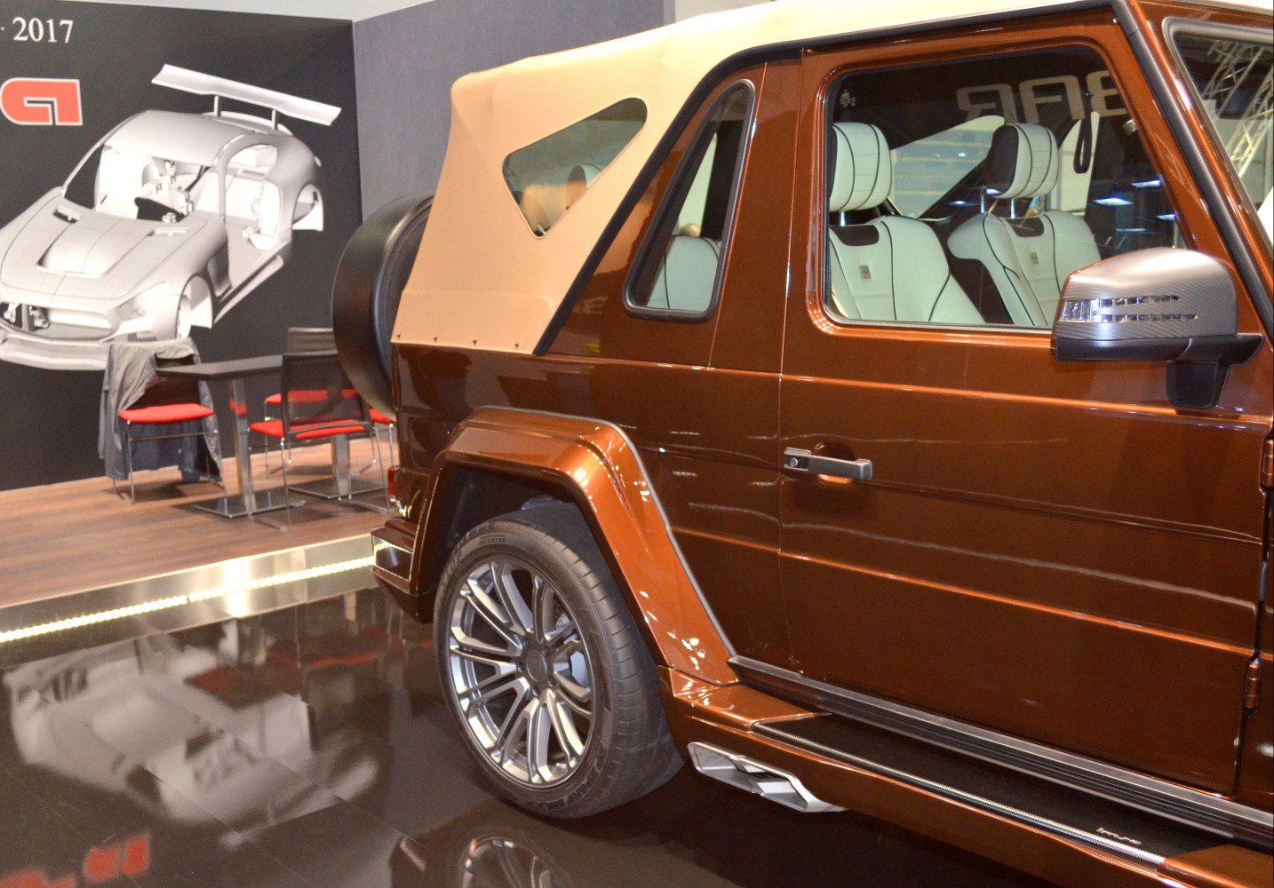 Rear side view of SUV with beige convertible soft top and alloy wheels
