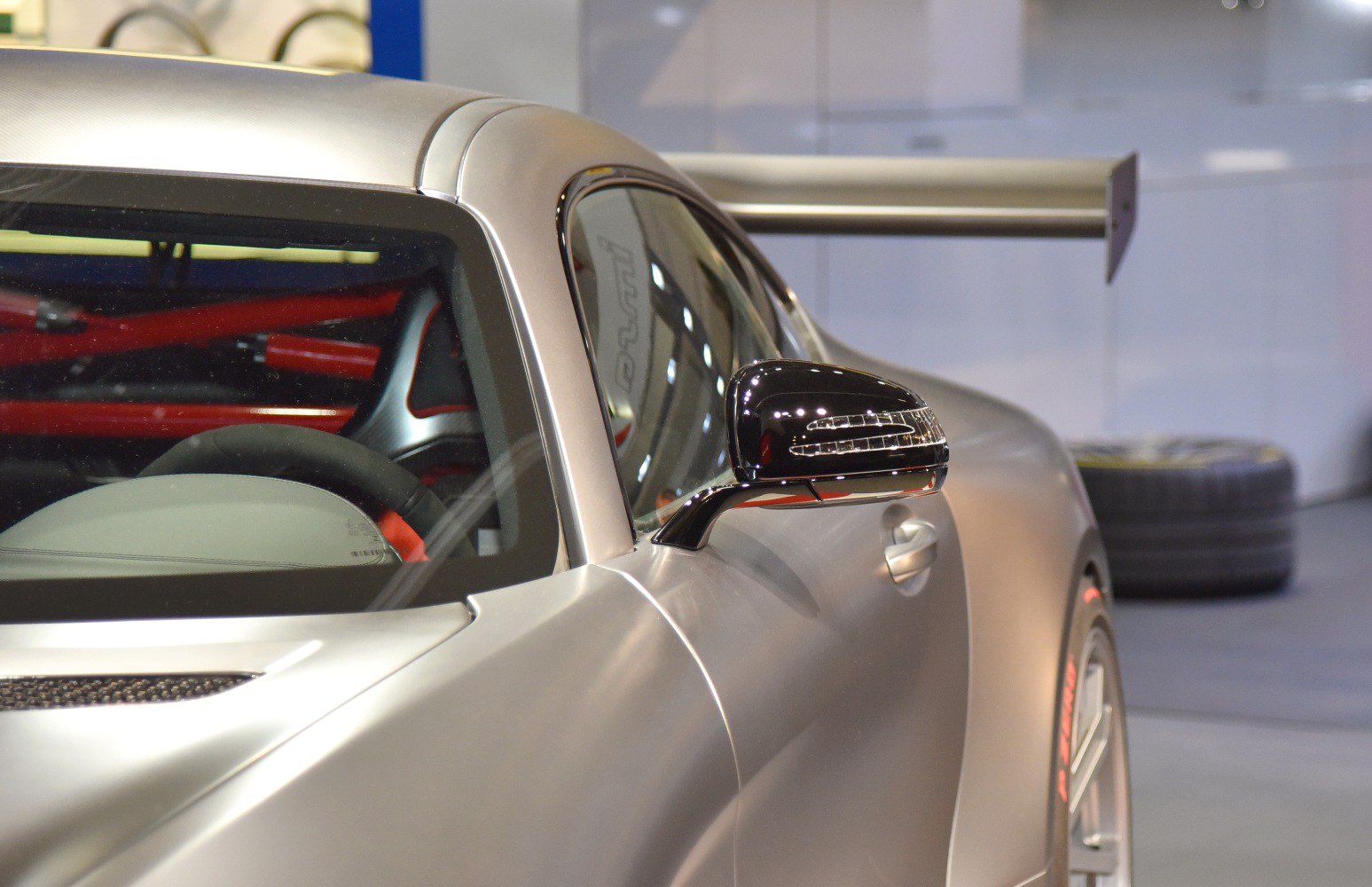 Close-up of car door, side mirror, rear wing, and roll cage