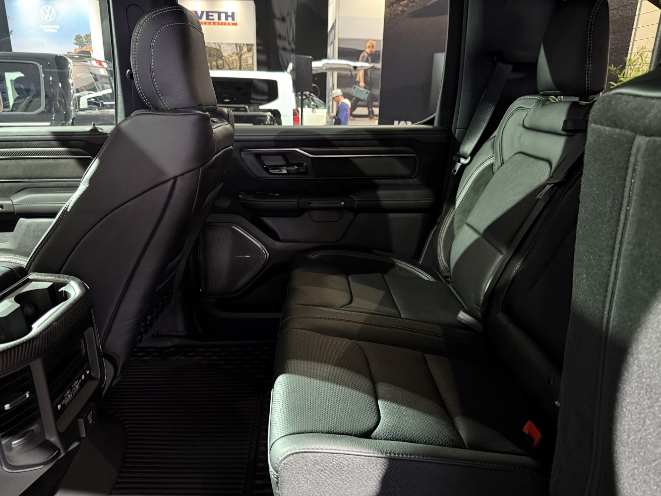 Spacious rear leather seats and detailed door panel of a modern truck interior.