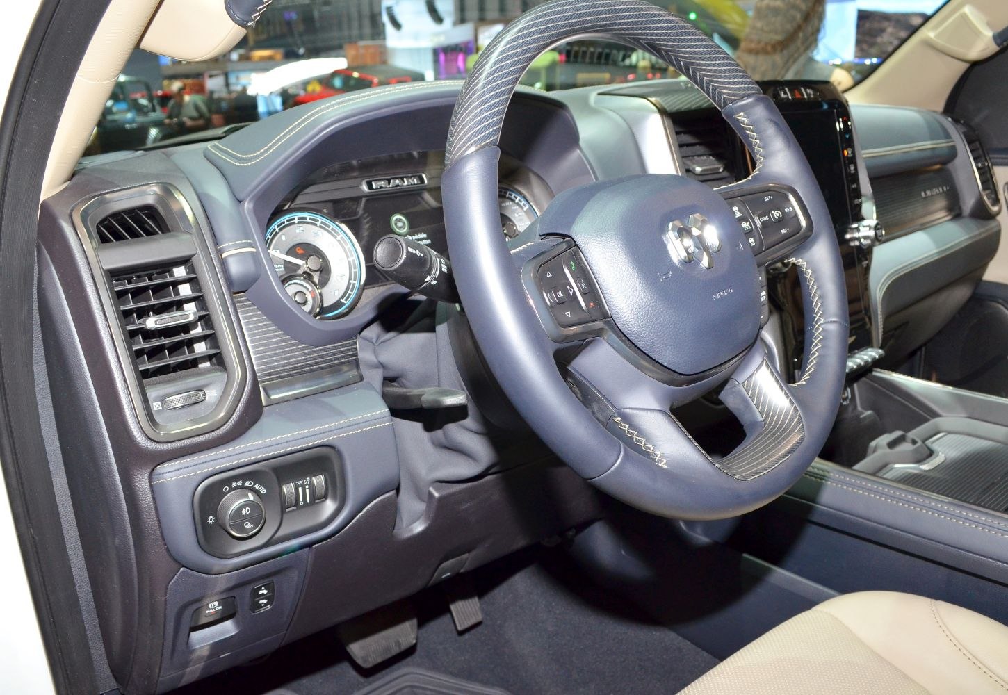 Steering wheel with control buttons and dashboard with instrument cluster.
