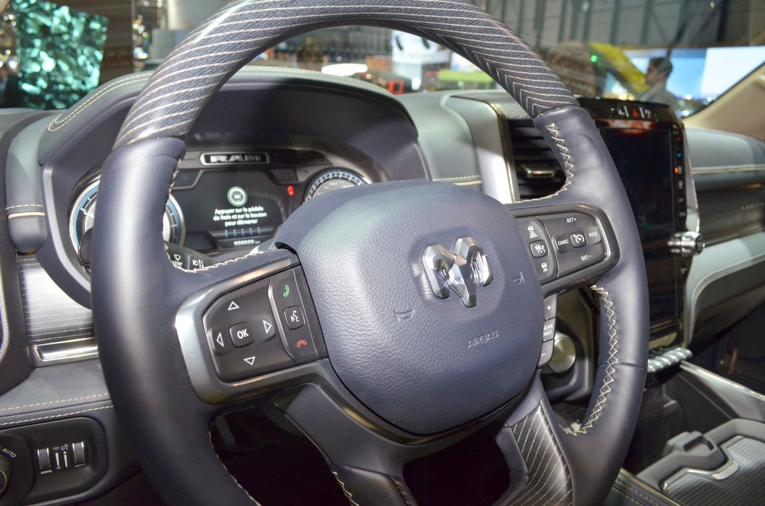 Leather-wrapped steering wheel with control buttons and detailed stitching
