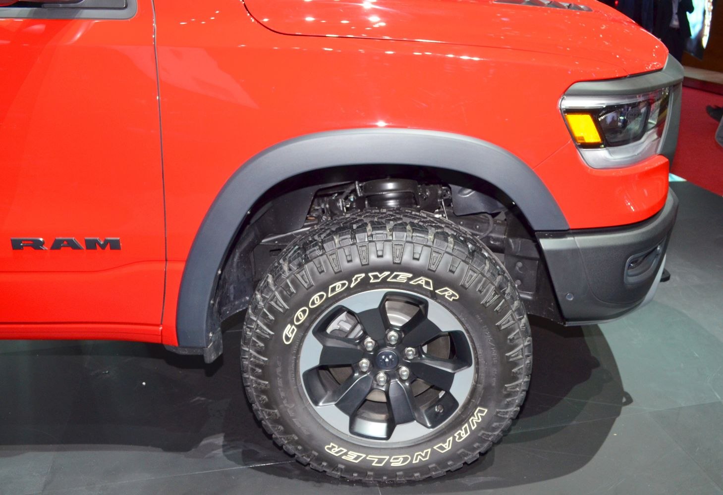 Front wheel and fender with Goodyear Wrangler tire on red truck