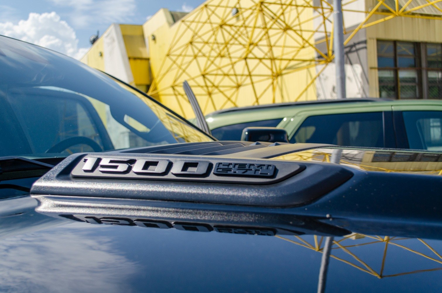 Close-up of '1500 HEMI 5.7L' hood badge on pickup truck