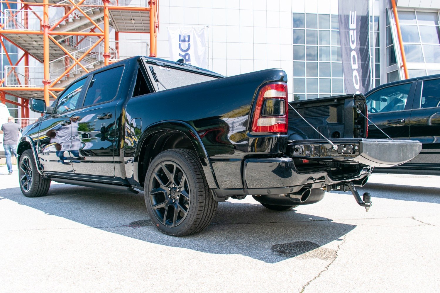 Black pickup rear view with open tailgate and dual exhaust
