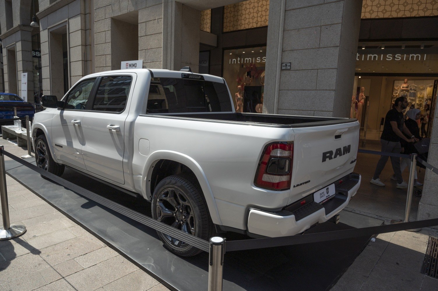 White pickup truck rear, side profile, spacious bed, black wheels.
