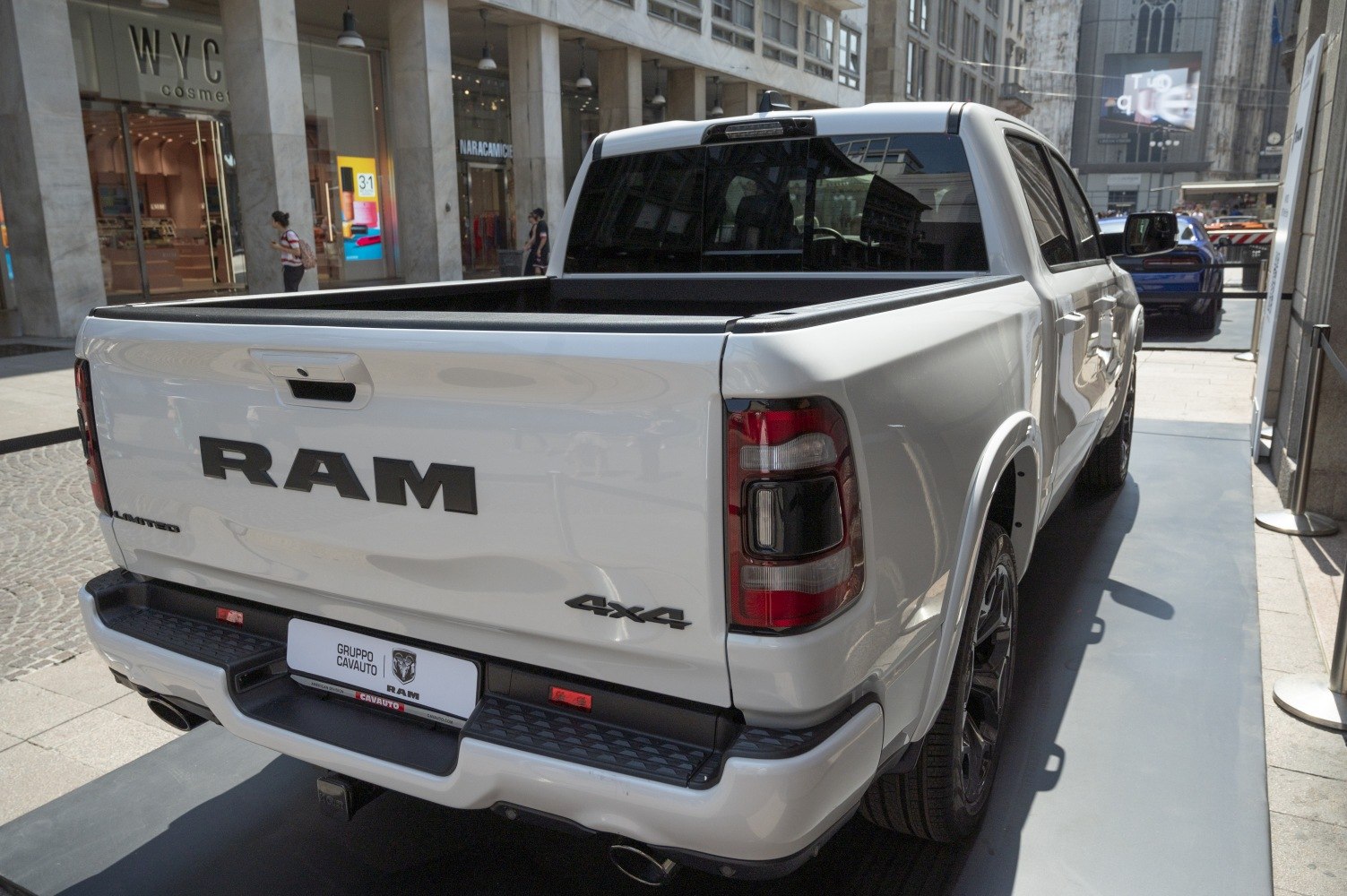 Rear view of a white 4x4 pickup truck with cargo bed and tail lights