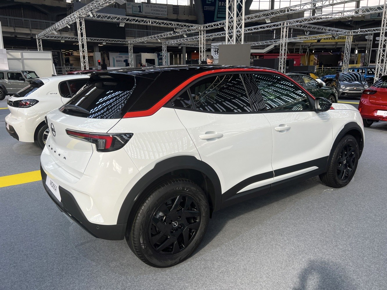 White compact SUV with black roof, red accent, and black alloy wheels