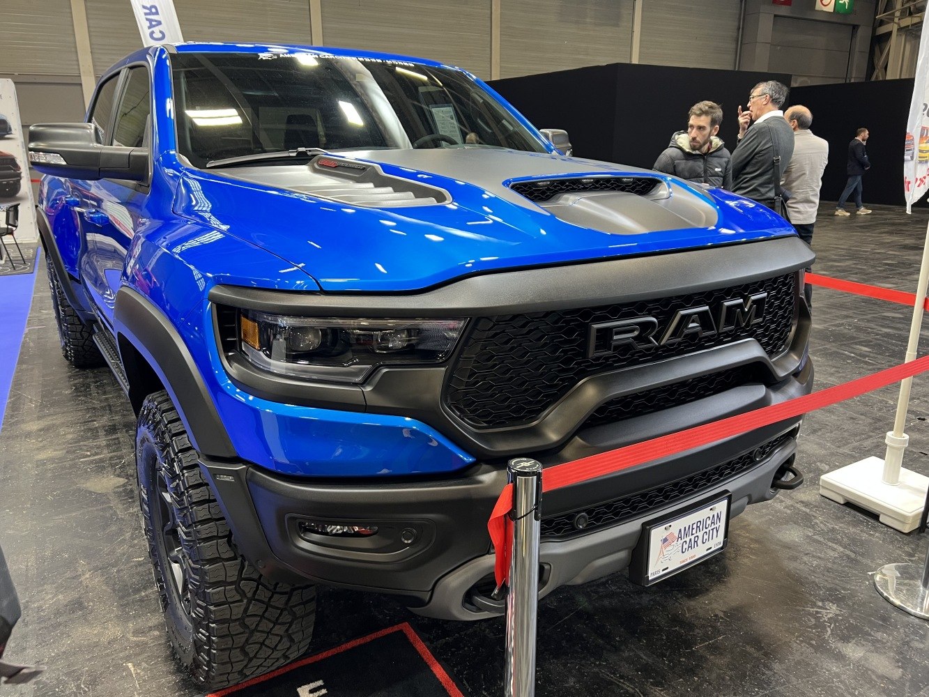 Blue pickup truck front with aggressive grille and hood scoop