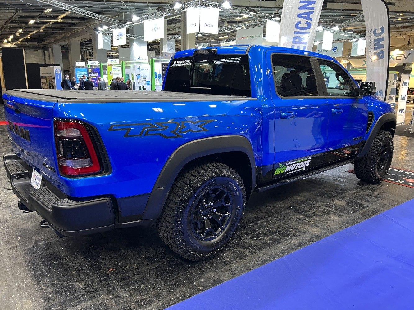 Blue pickup with TRX badge, crew cab, all-terrain tires, and covered bed