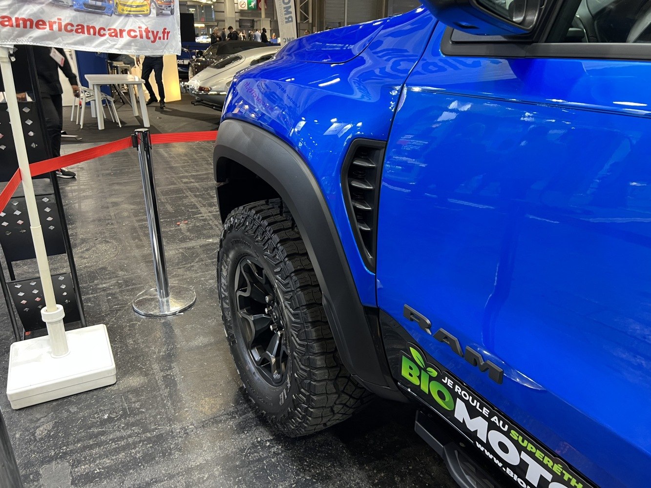 Off-road tire and black fender flare on blue pickup side