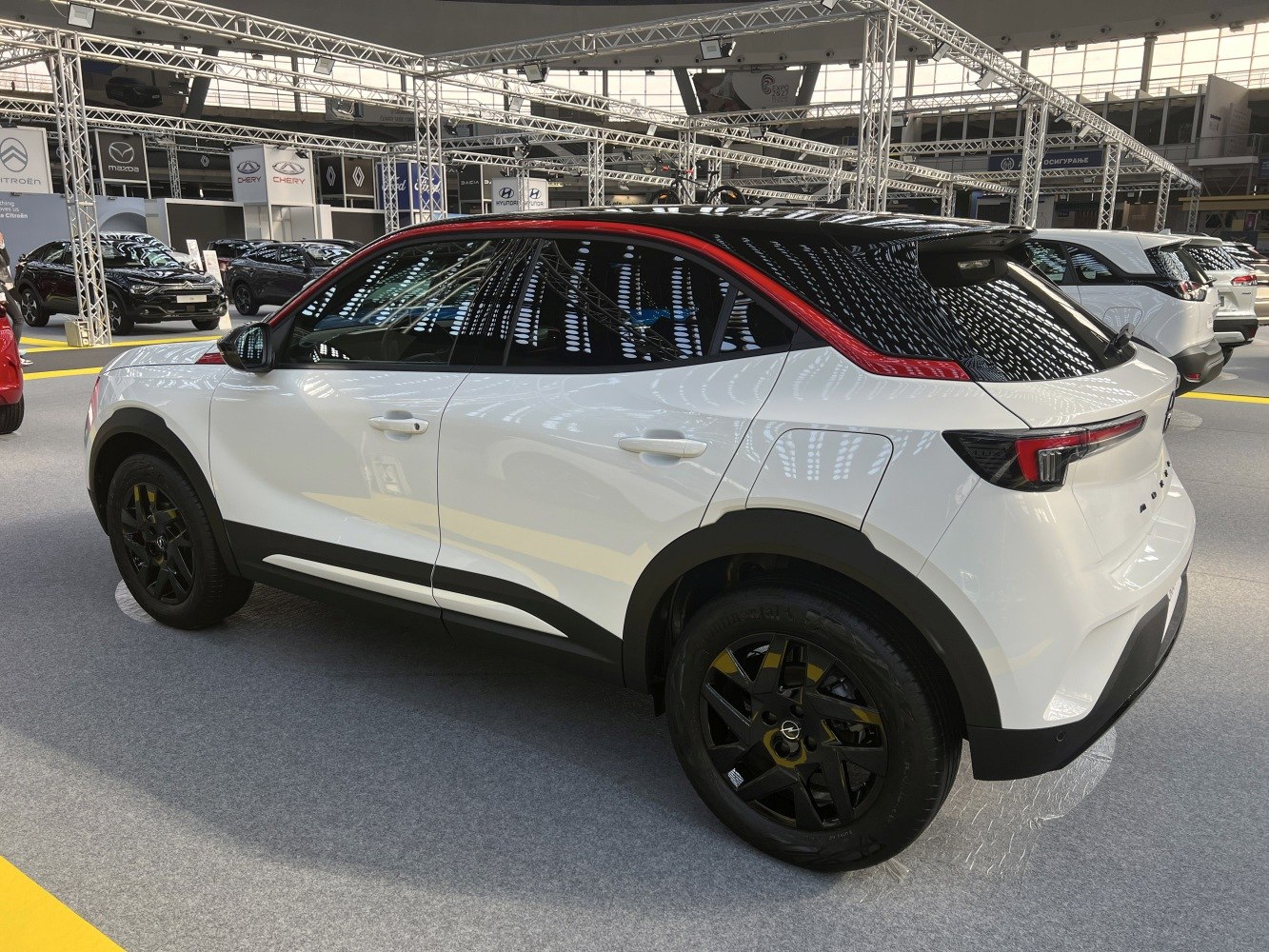 White compact SUV with black roof and red trim, rear and side view.
