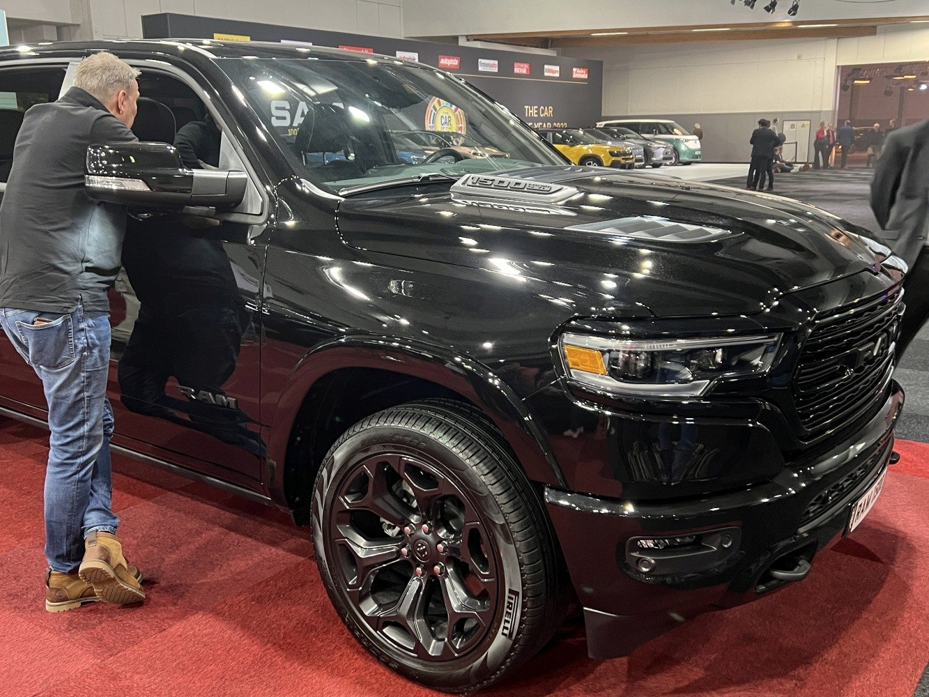 Front exterior close-up with black alloy wheels and hood scoop.