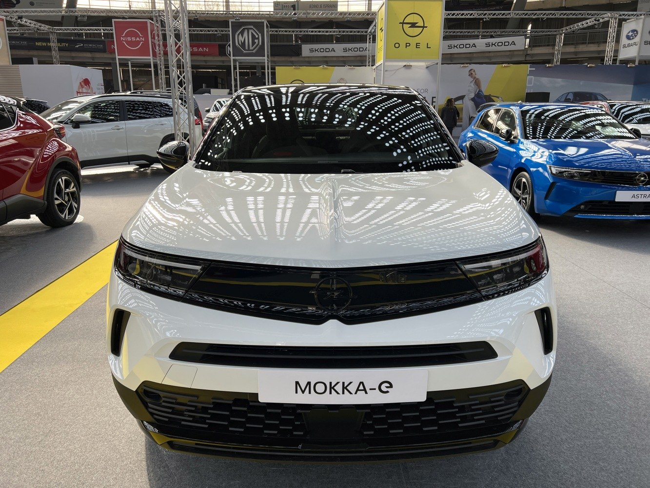 Front view of white electric SUV with sleek LED headlights and modern grille