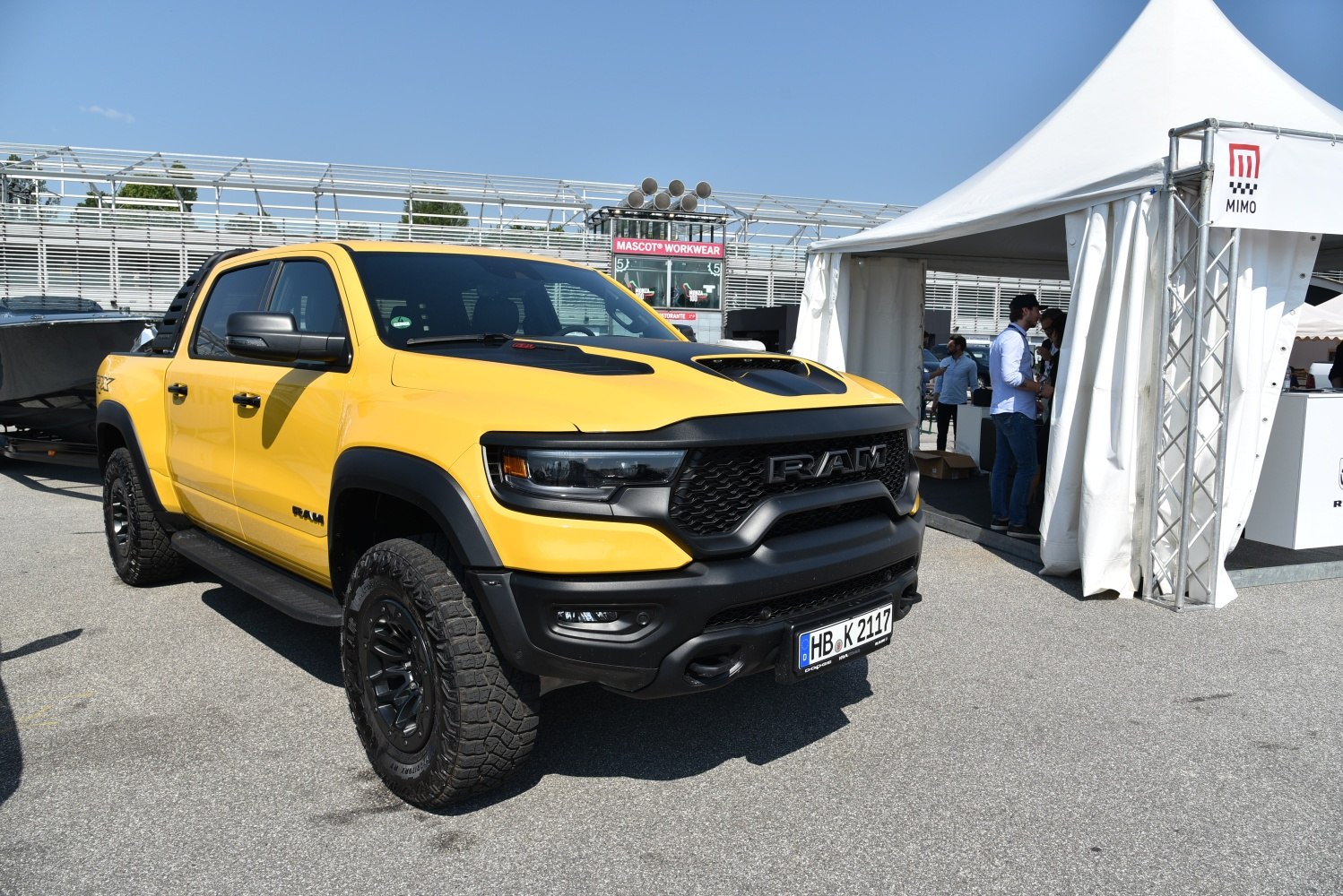 Yellow off-road pickup with black grille, hood scoop, and rugged tires