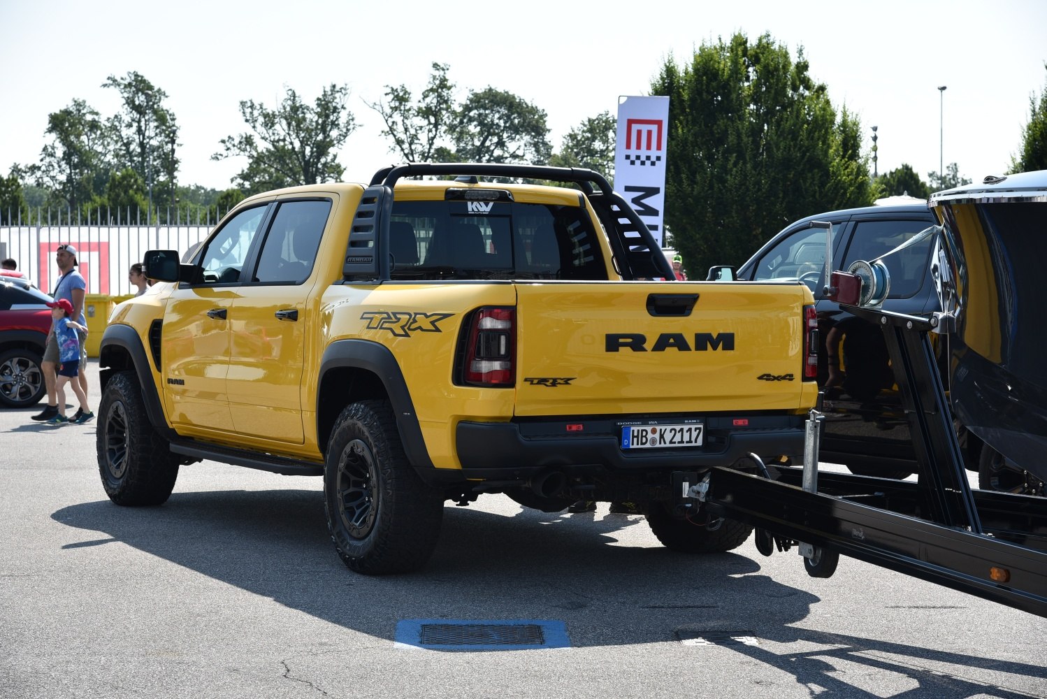 Yellow pickup with rear view, roll bar, off-road tires, and 4x4 badge